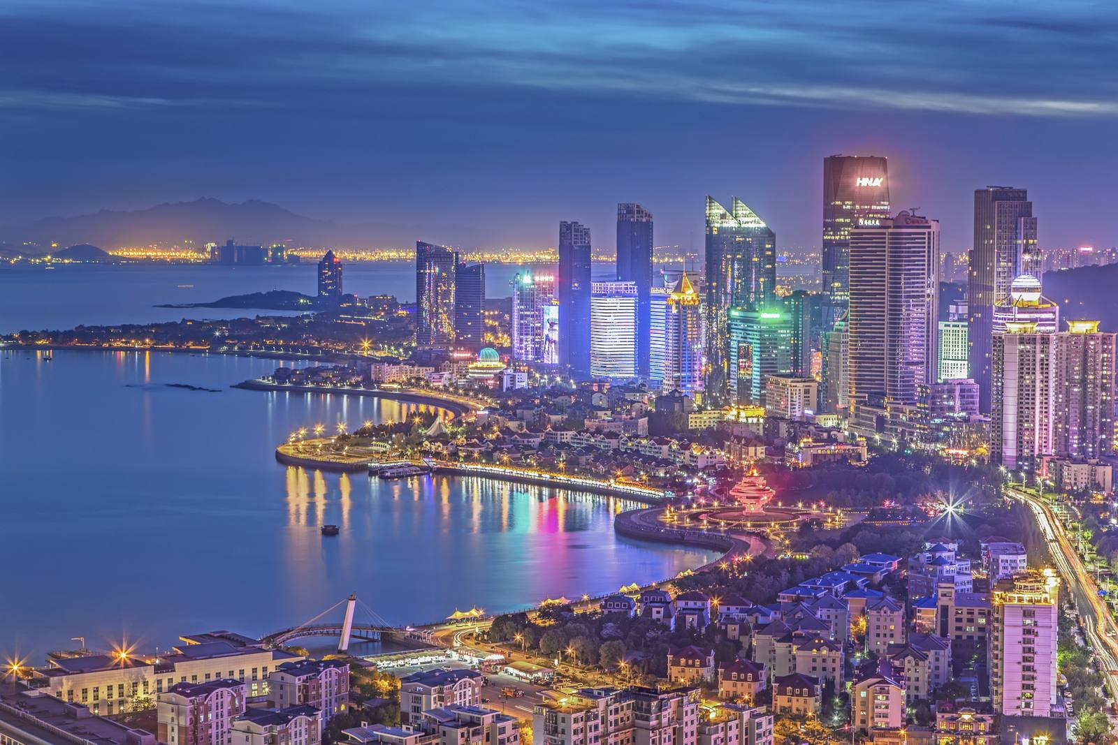 Aerial view of Qingdao's coastline and skyline at dusk
