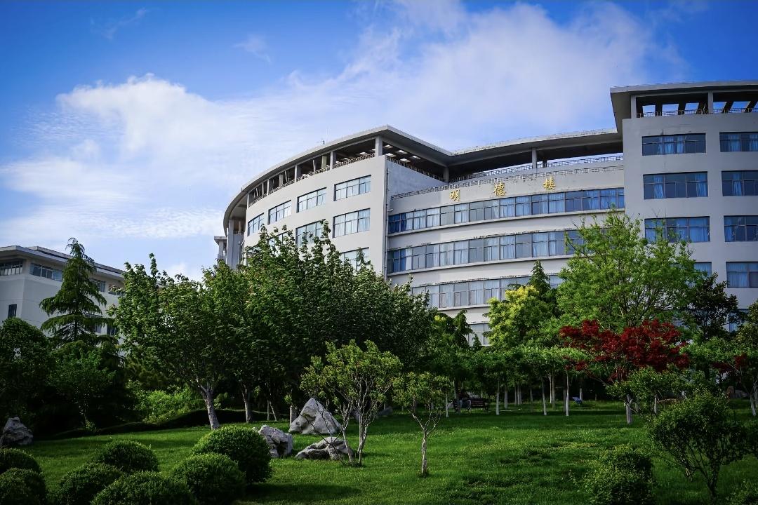 A modern university campus building in Qingdao surrounded by gardens